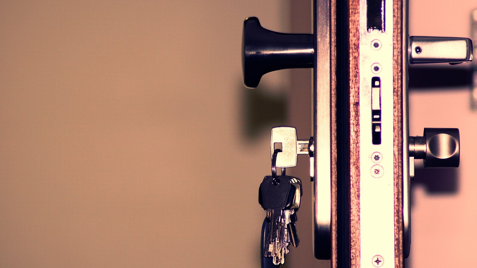 A locksmith fitting a lock to a door